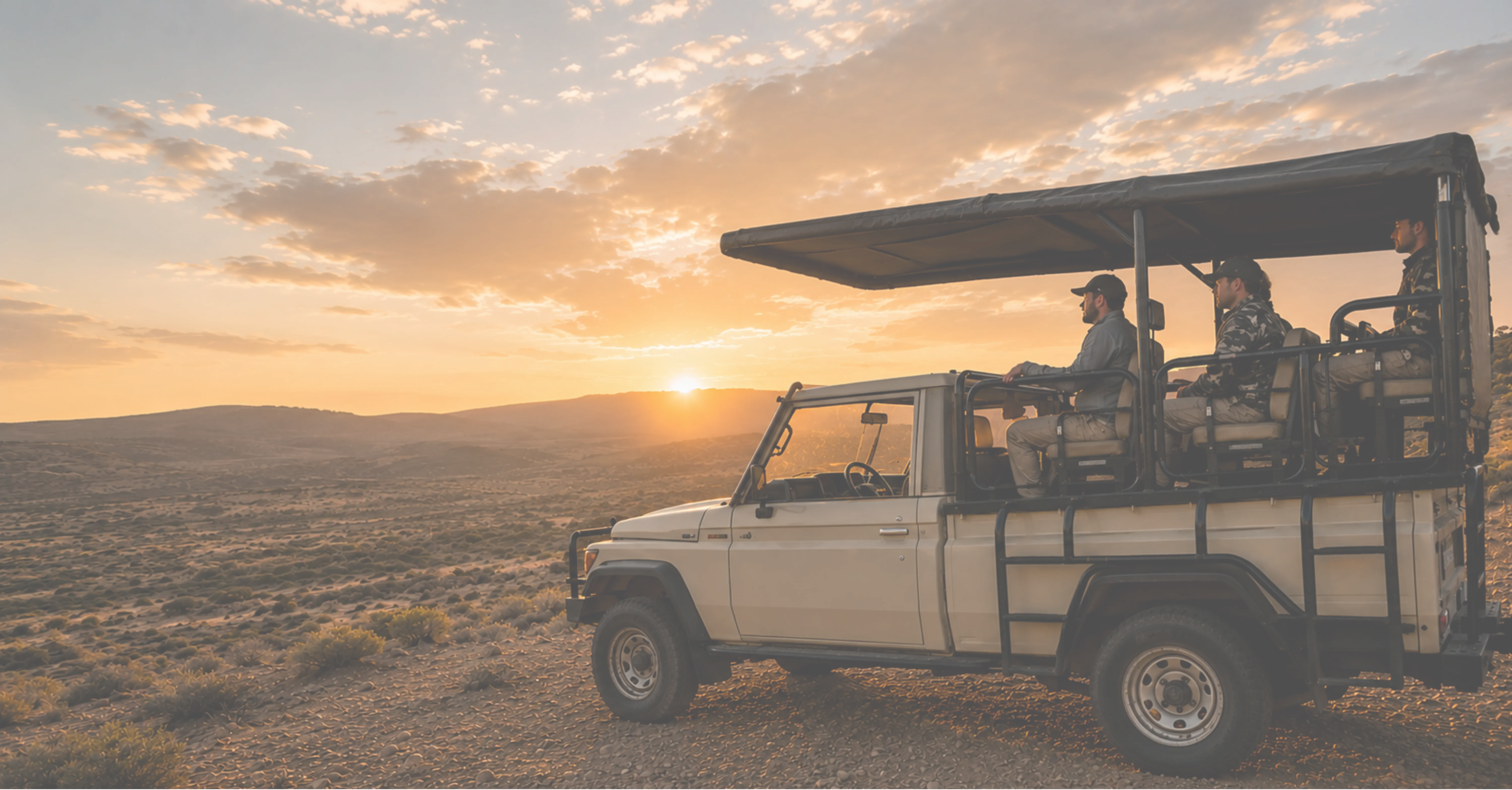 Safari vehicle crossing the Northern Cape landscape at sunset